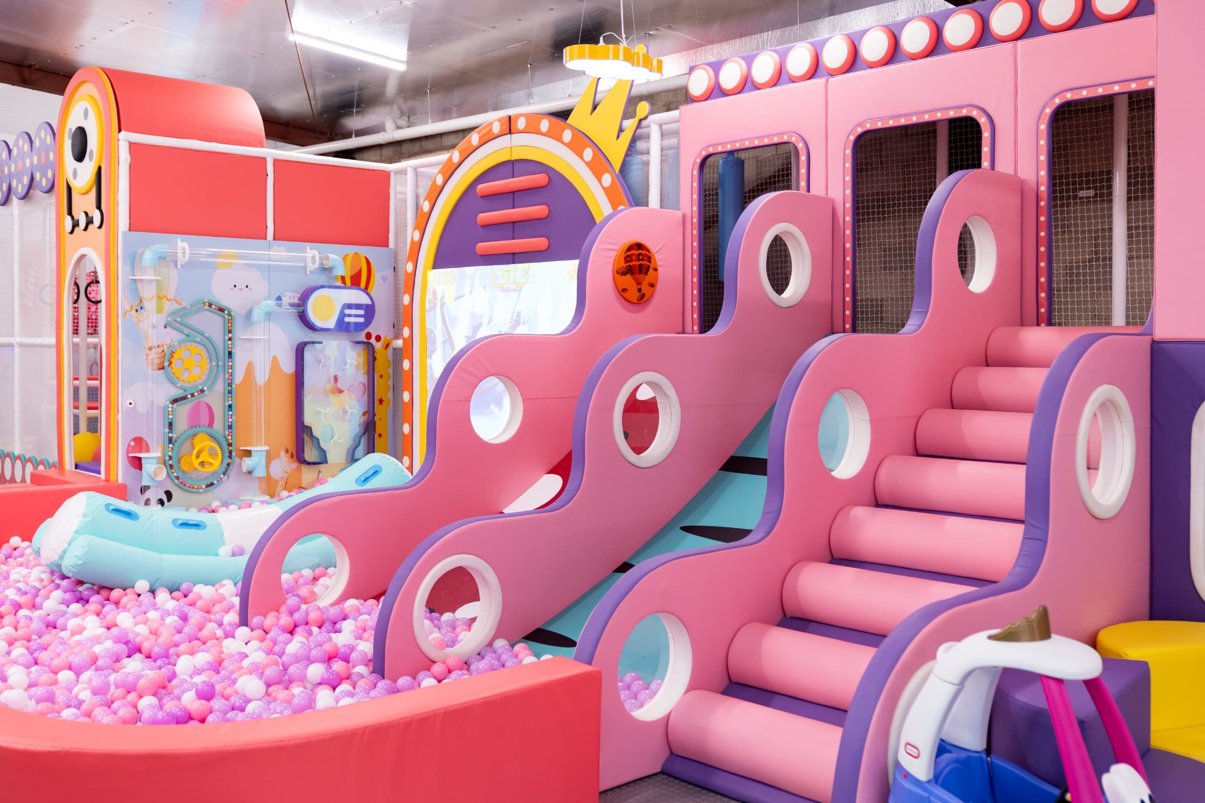 A warm birthday celebration scene with balloons, a styled cake table, and children playing nearby.