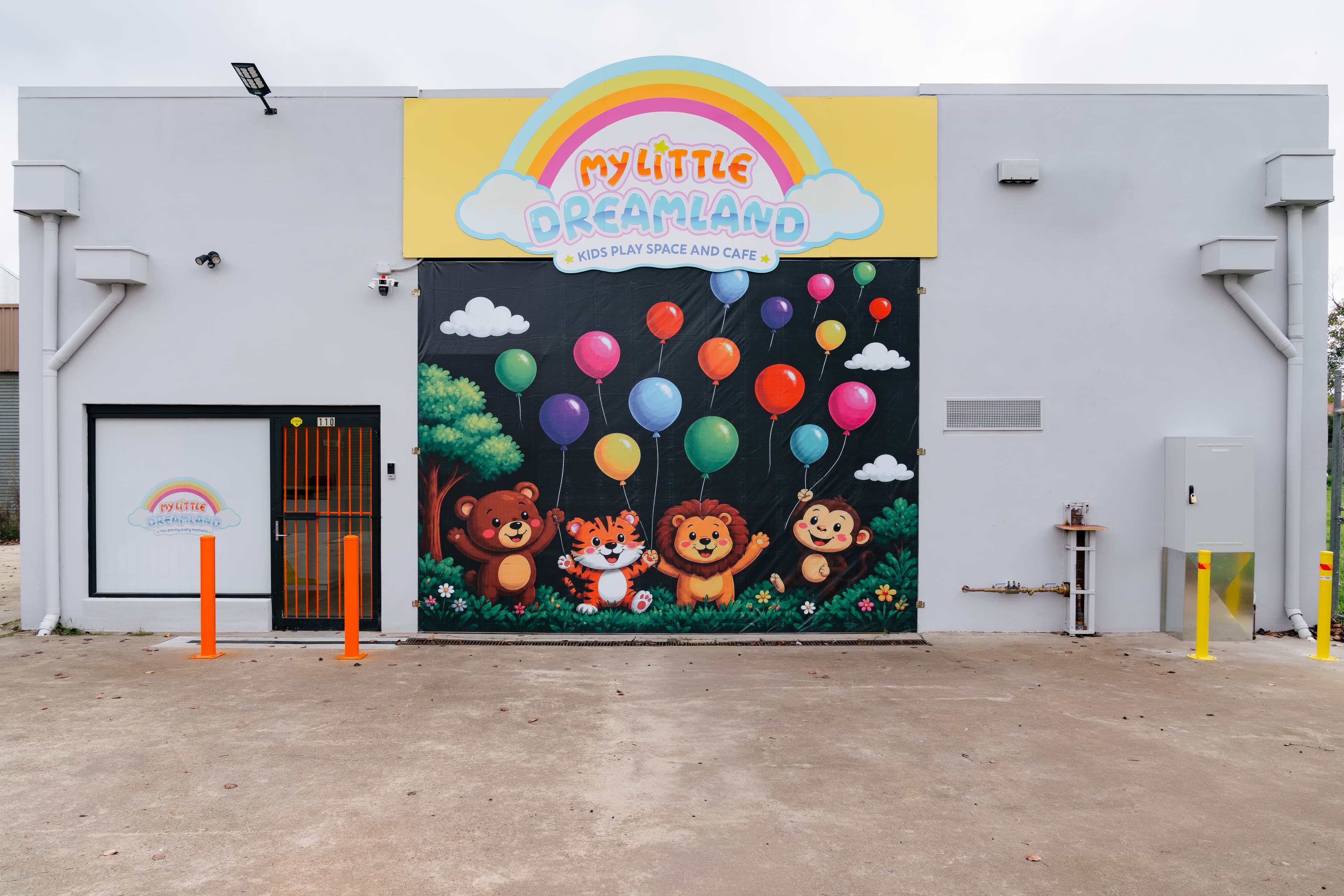 Parents settling in while young children begin exploring a soft pastel play space.